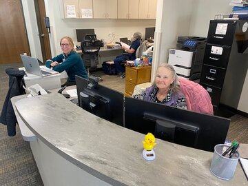 Two females sitting at desk in the rehab department.