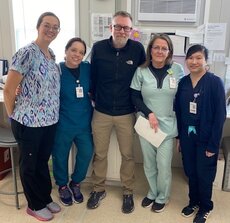 Laboratory team standing next to each other, smiling.