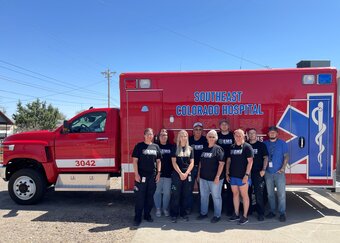 SECHD EMS Service staff memebers standing outside in front of a ambulance truck.